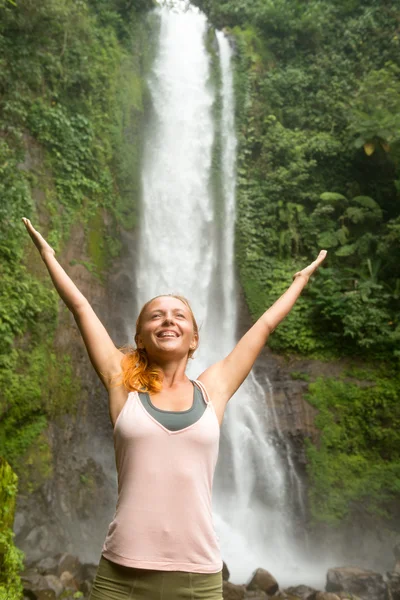 Mujer joven practicando yoga junto a la cascada — Foto de Stock