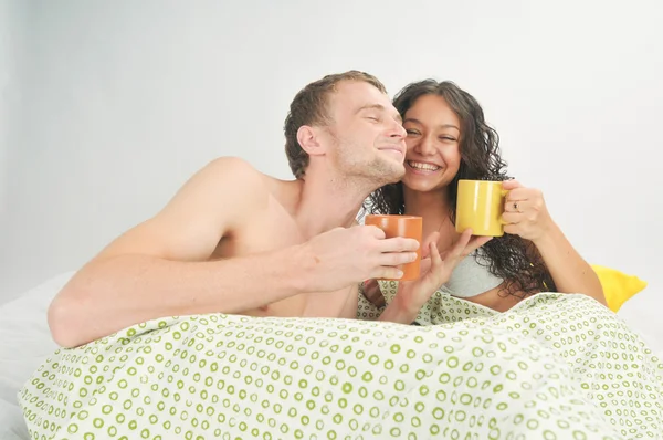 Pareja joven en la cama con café —  Fotos de Stock