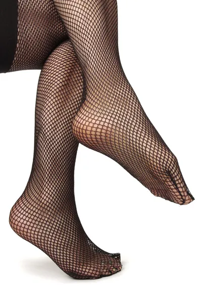 Jambes de femme portant des collants résille noirs sur fond blanc — Photo