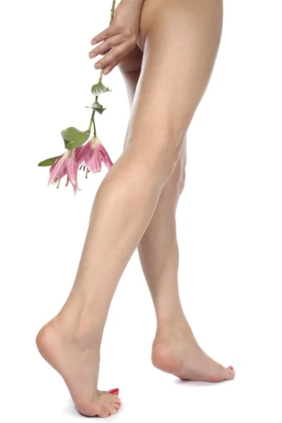 Γυναικεία πόδια με λουλούδια που απομονώνονται σε λευκό φόντο — Φωτογραφία Αρχείου