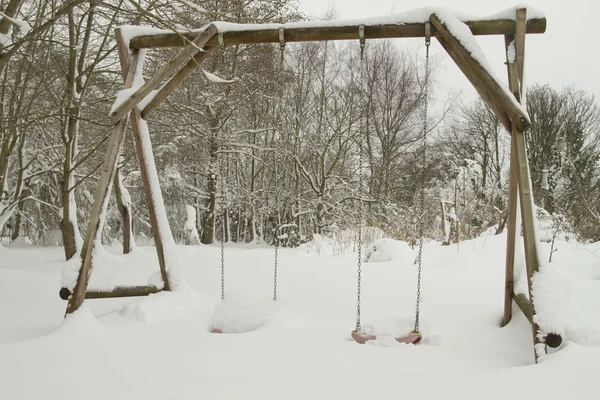 Swings covered in snow — Stock Photo, Image