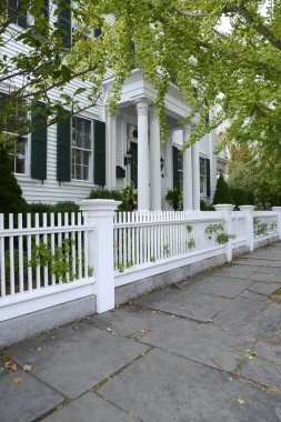 white picket fence by a typical federal style house clipart