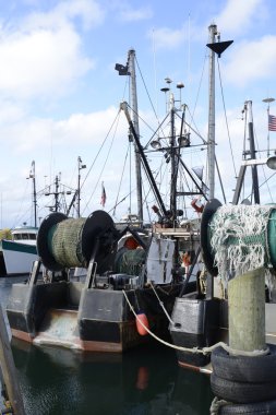 commercial fishing boats by a wood dock clipart