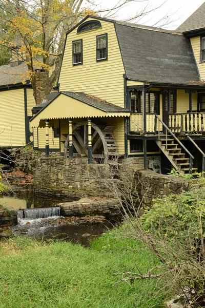 Žlutý dům s waterwheel a vodopád — Stock fotografie