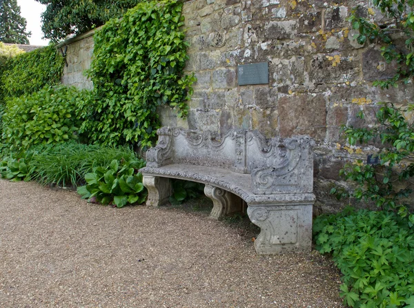 Asiento de piedra contra pared —  Fotos de Stock