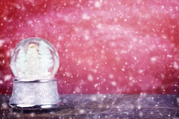 Globo de neve contra vermelho — Fotografia de Stock