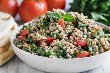 Tabbouleh salatası. Geleneksel Levantine ortadoğu ya da iftar için maydanoz, nane, bulguru ve domatesle yapılan Arap yemeği. Pita ekmeğiyle servis edilmiş. Bulanık arkaplan ile seçmeli odak.