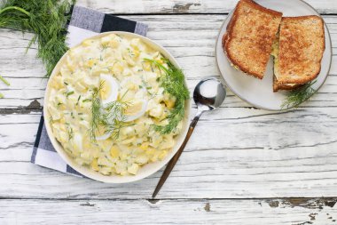 Yumurta salatasının üst görüntüsü haşlanmış yumurta ve dereotla kaplanmış ve ahşap bir arka planda kızarmış sandviç. Genel Görünüm.