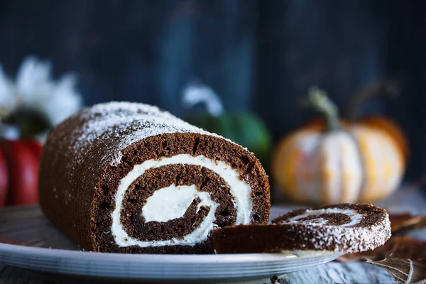 Taze fırında çikolatalı, yuvarlak balkabaklı kek, pudra şekeri ve krem peynirli. Bulanık arkaplan ile aşırı seçici odak. 