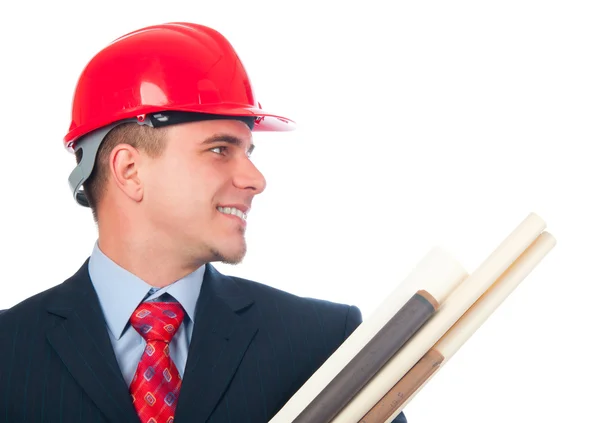 Bello ingegnere sorridente con cappello duro sulla testa e cianografie tra le braccia — Foto Stock