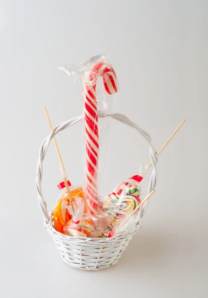 화이트에 고립 된 작은 흰색 바구니에 다채로운 막대 사탕 — 스톡 사진