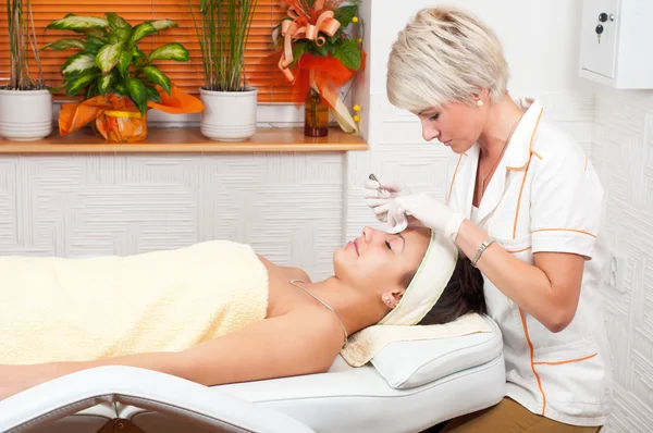 Beautiful young woman receiving a cosmetic treatment in beauty salon — Stock Photo, Image