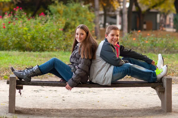 Adolescent garçon et une fille avoir du plaisir dans le parc sur belle journée d'automne . — Photo