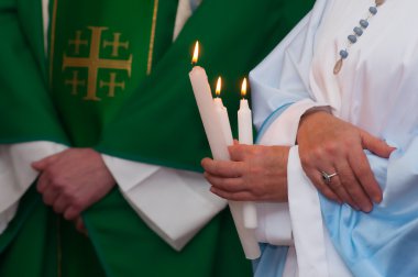 ayrıntı gösteren elbiseler ve rahiplerin üç beyaz mum tutan eller advent kitle