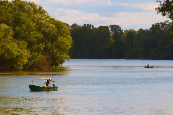 Pescatore sulle barche sul fiume calmo nella soleggiata giornata estiva — Foto Stock