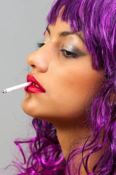 Profile of the beautiful girl with cheap purple wig smoking — Stock Photo, Image