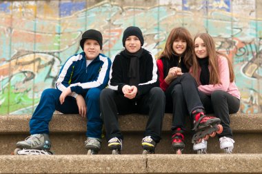 mutlu genç paten sokakta oturan grup