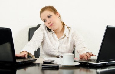 Stressed business woman multitasking in her office using latest technology. clipart