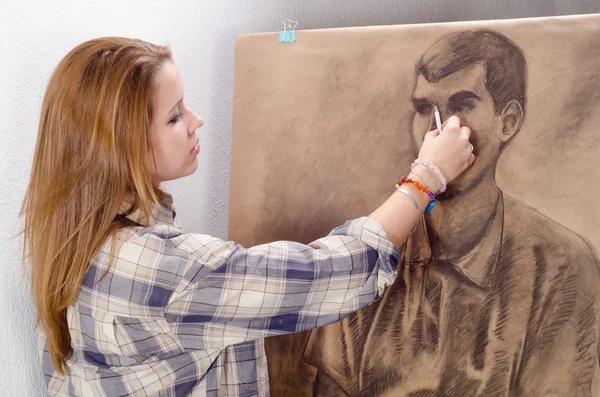 Jeune artiste féminine dessinant un portrait d'homme dans son atelier d'art . — Photo