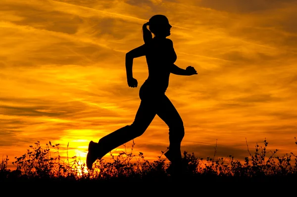 Silhouette of the running girl at sunrise. — Stock Photo, Image