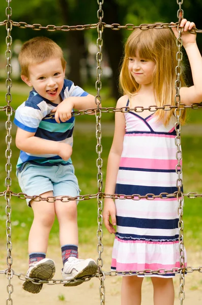 Брат и сестра играют на детской площадке — стоковое фото