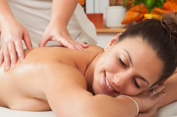 Mujer joven recibiendo masaje en el salón de masajes —  Fotos de Stock