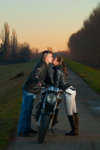 Casal beijando sobre a moto — Fotografia de Stock