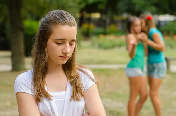 Zwei Teenager-Mädchen machen sich über die dritte lustig — Stockfoto