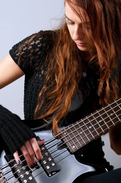 Menina bonita tocando guitarra baixo — Fotografia de Stock