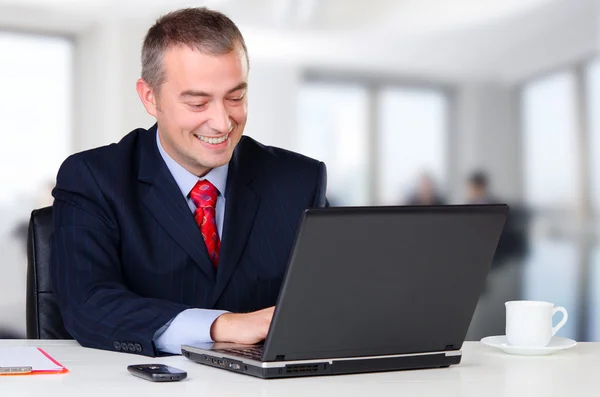 Jovem homem de negócios feliz trabalhando no notebook — Fotografia de Stock