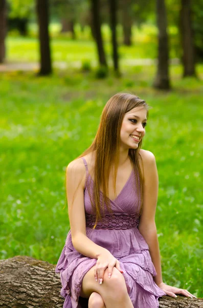 Mooi meisje zit in het park — Stockfoto