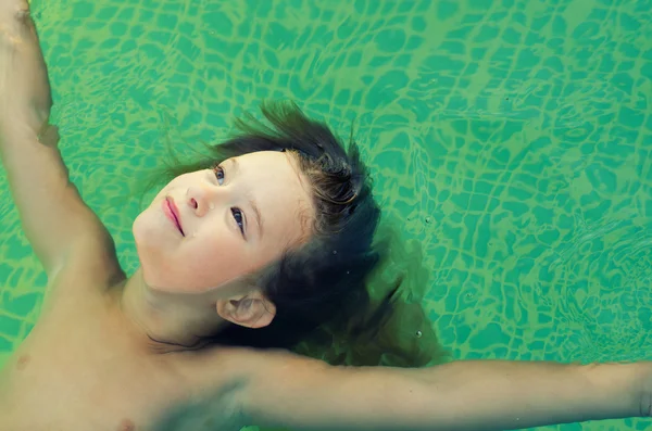 Petite fille flottant sur la surface de l'eau — Photo