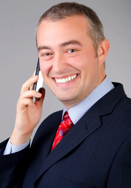 Un hombre de negocios sonriente hablando por teléfono — Foto de Stock