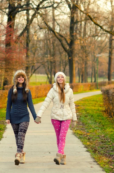 Två tonårsflickor promenader i parken — Stockfoto