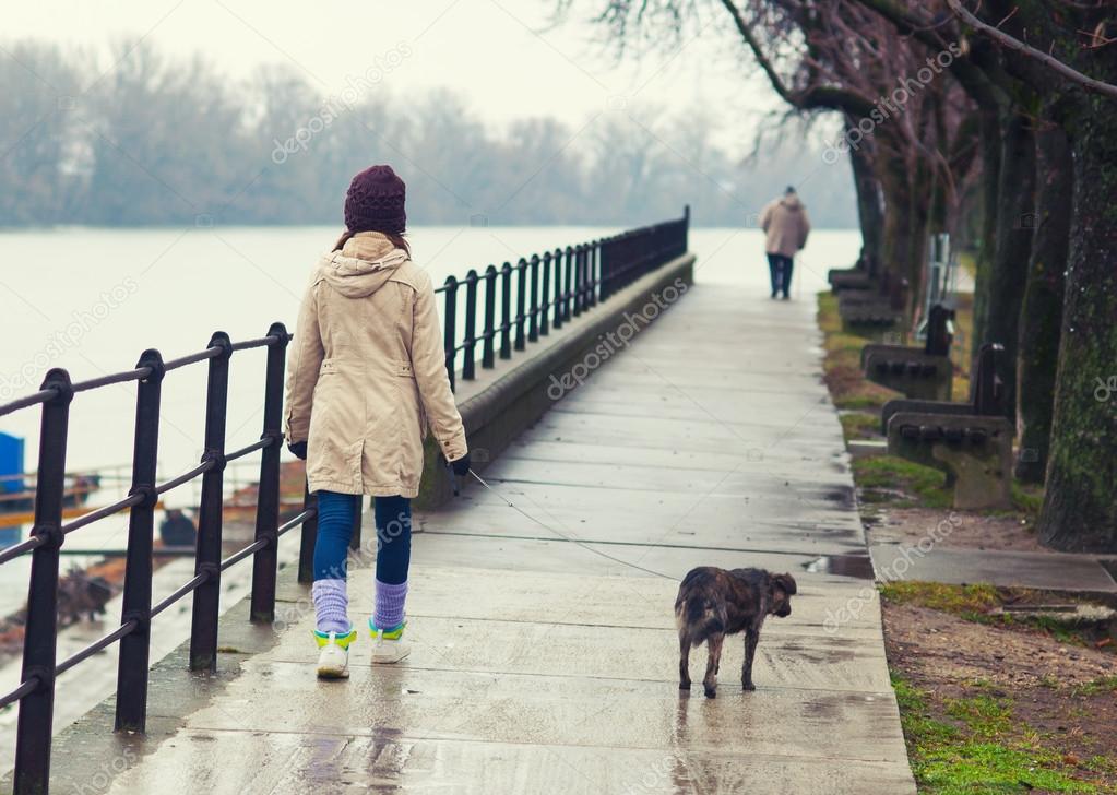 Teenage girl walking the dog in winter