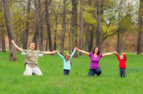 Familia joven divirtiéndose en el bosque — Foto de Stock