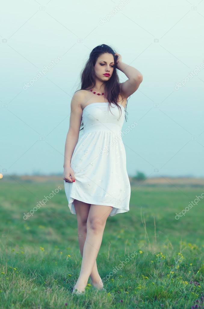 Beautiful girl walking on the meadow