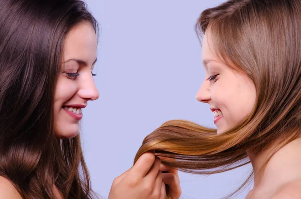 Mooie meisjes spelen met hun haren — Stockfoto