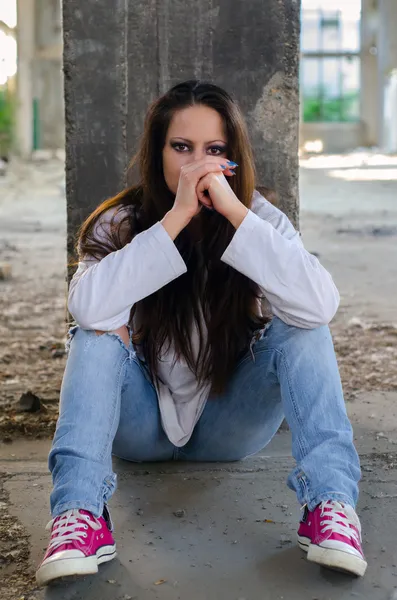 Jovem deprimida sentada no prédio abandonado — Fotografia de Stock