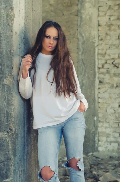 Depressed young girl standing beside concrete column in abandone — Stock Photo, Image