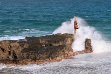 Adventerous woman enjoying big waves clipart