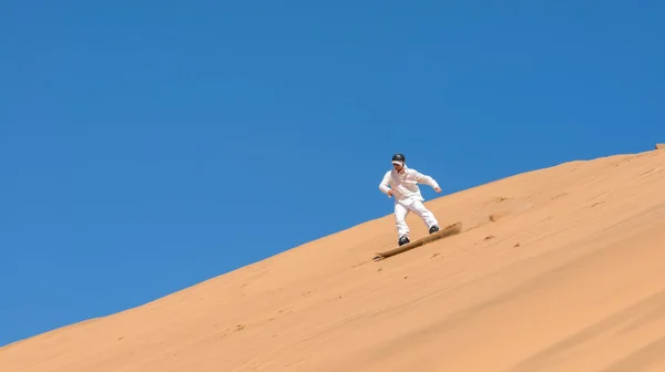 Man sandboarden in Namibië — Stockfoto