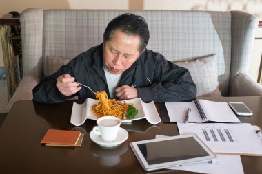 Orta yaşlı adam yeme erişte 