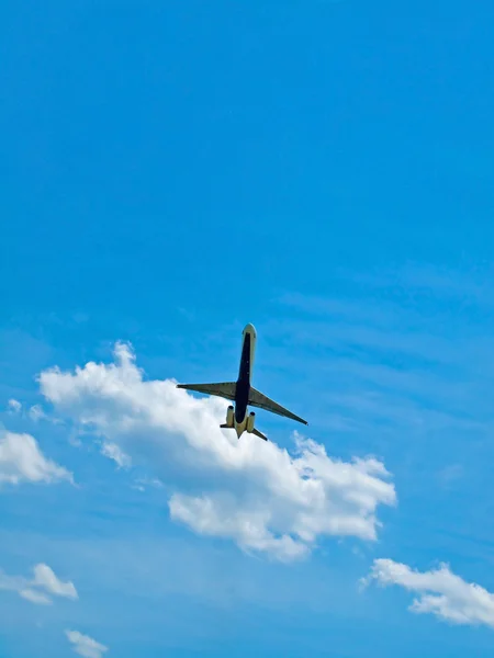 Коммерческий авиалайнер взлетает в частично облачное голубое небо — стоковое фото