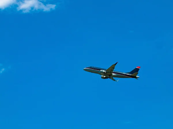 Un avion de ligne commercial décollant dans un ciel bleu partiellement nuageux — Photo