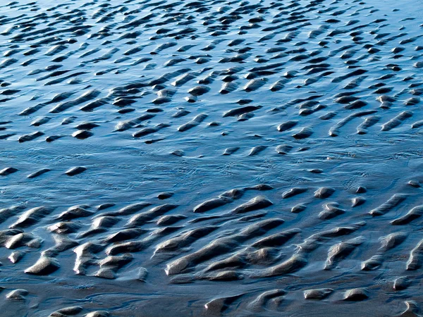 Ondulações oceânicas e areia em águas rasas em uma praia — Fotografia de Stock