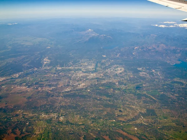 Vista de un paisaje montañoso cubierto de nieve desde un avión —  Fotos de Stock