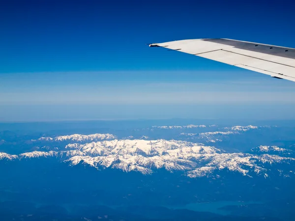 Vista de un paisaje montañoso cubierto de nieve desde un avión — Foto de Stock