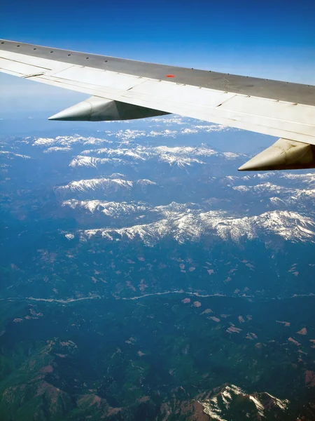 Vista de un paisaje montañoso cubierto de nieve desde un avión — Foto de Stock