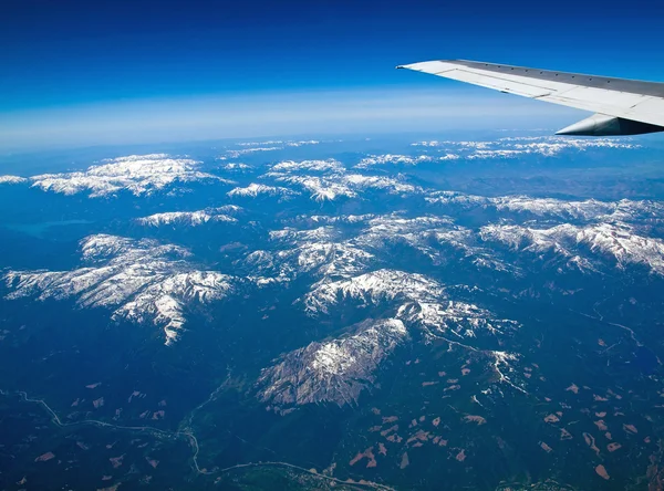 Vista de un paisaje montañoso cubierto de nieve desde un avión — Foto de Stock